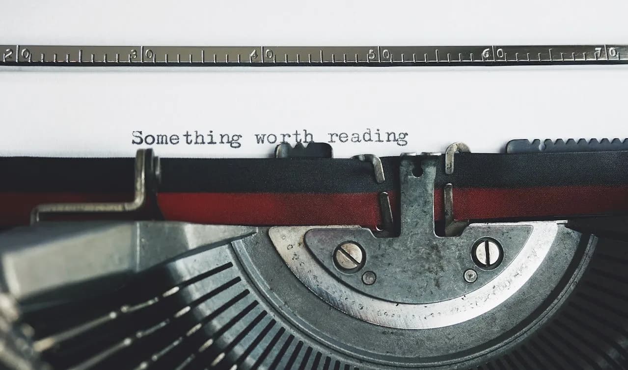 A typewriter with a paper and a line of text quoting something worth reading