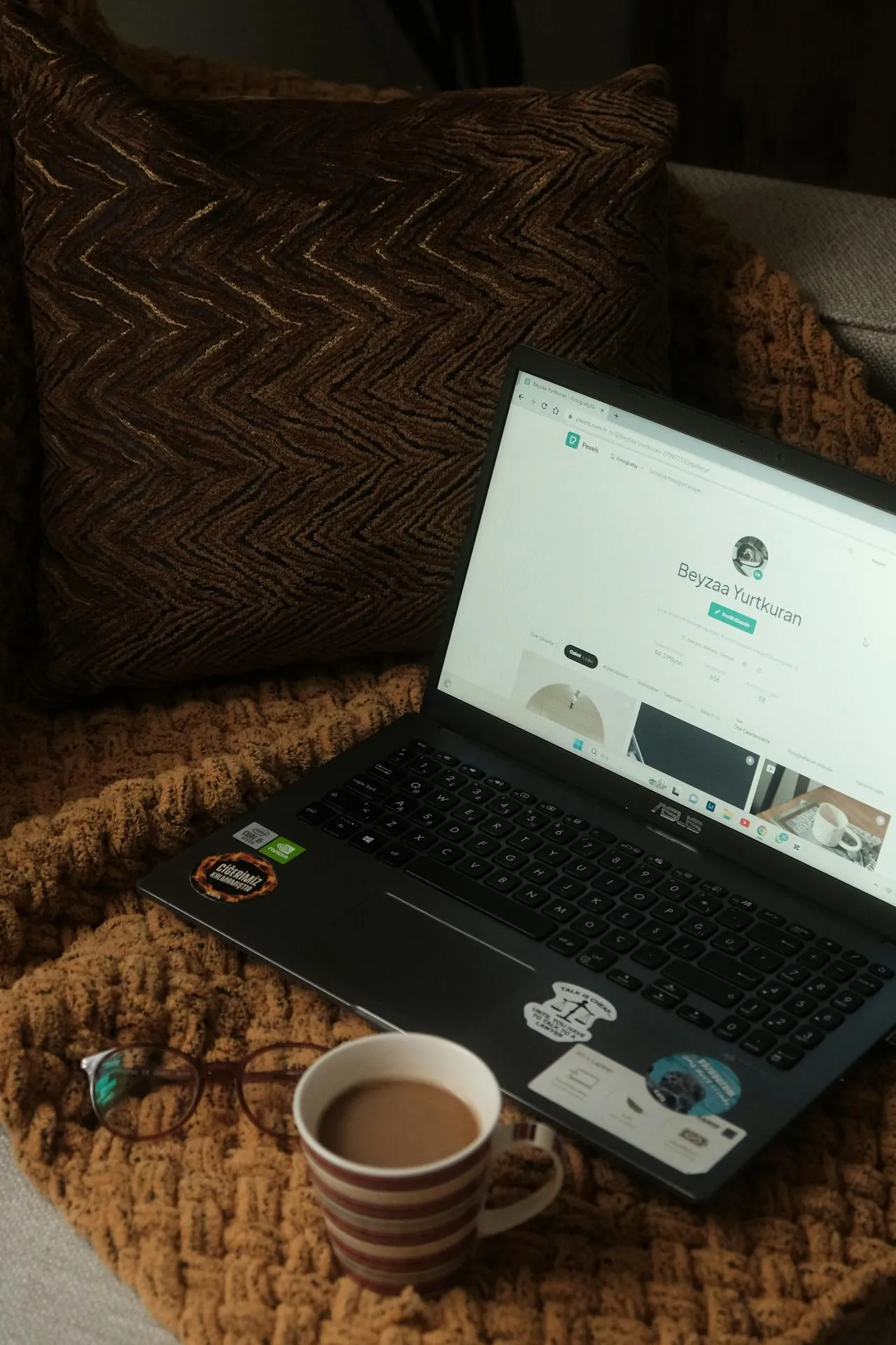 A laptop and a coffee on bed